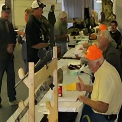 Men at registration table with orange hats